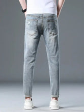 Men’s plus size light-wash slim fit distressed jeans with slight stretch and rolled cuffs in a casual style