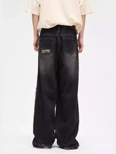 Men’s plus size black wide leg denim jeans with faded distressed finish and patchwork on the back pockets shown from back side