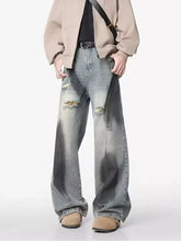 Men’s plus size distressed wide leg jeans in faded gray wash with intentional rips and frayed hems