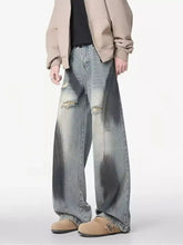 Men’s plus size distressed wide leg denim jeans with a faded look and intentional dark gray splotches