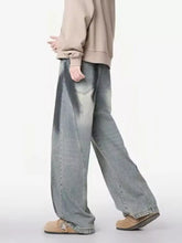 Men’s plus size distressed wide leg jeans in faded light blue denim with subtle distressing and raw hem detailing