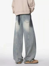 Men’s plus size distressed wide leg denim jeans in faded light blue wash showing back side with darkened pockets