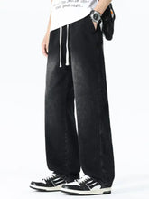 Men’s plus size drawstring wide leg jeans in black denim with white drawstrings and faded distressed texture