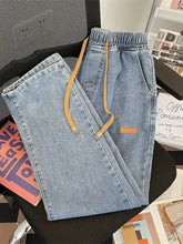 Men’s plus size light-wash denim wide leg jeans with tan drawstrings and matching patch on the thigh