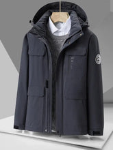 Dark gray plus size hooded zip up winter jacket with multiple pockets and circular logo patch on left sleeve