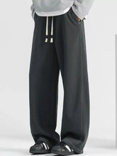 Men’s plus size loose fit wide leg jeans in black sweatpant material with white drawstrings and subtle side seam stitching