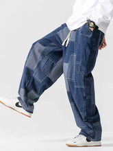 Men’s plus size patchwork wide leg jeans in blue denim with contrasting stitching and a drawstring waist