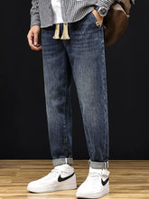 Men’s plus size relaxed fit dark blue denim jeans with drawstring waist rolled cuffs and decorative tassels