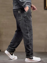 Men’s plus size relaxed fit dark gray denim jeans with drawstring waist and small black patch on back pocket shown from back