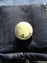 A brass-colored button with classic wear engraving on dark denim men’s plus size relaxed fit jeans