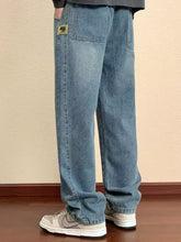 Men’s plus size light-wash denim relaxed fit jeans with a straight-leg cut and yellow patch on the back pocket