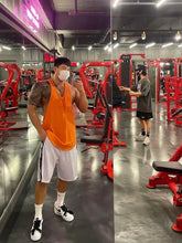 Muscular man in mens plus size round neck racerback orange tank top, gym mirror selfie