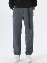 Men’s plus size solid loose fit pants in dark gray with black drawstring and white sneakers