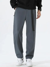 Men’s plus size solid loose fit pants in dark gray with black belt and white sneakers