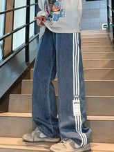 Men’s plus size striped wide-leg jeans in blue denim with three white vertical stripes and a small brand tag near the bottom