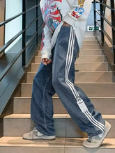 Men’s plus size striped wide-leg jeans in blue denim with three white stripes and a small logo patch near the bottom