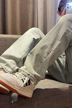 White adidas sneakers with orange soles and black stripes paired with men’s plus size vintage wash loose fit jeans