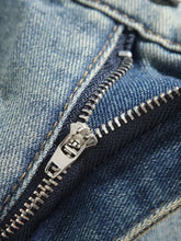 Silver zipper with metallic pull tab on medium-wash denim in men’s plus size vintage wash wide leg jeans