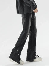 Men’s plus size black denim washed flare jeans with silver button detailing and snap-down hem along side seams
