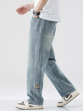 Men’s plus size light-wash denim jeans with relaxed fit, straight-leg cut, and brown patch label on lower leg