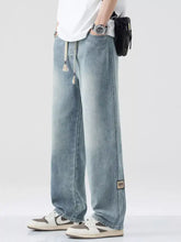 Men’s plus size light-wash denim relaxed fit jeans with wide-leg cut and tassel drawstring waistband