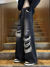 Men’s plus size wide leg distressed black denim jeans with layered frayed ripped patches on the legs