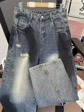 Men’s plus size wide leg distressed jeans in faded blue denim with high-waisted ripped details