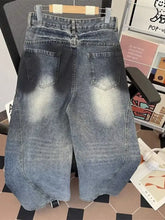 Men’s plus size wide leg distressed jeans in faded blue denim with subtle distressing and raw hem edges