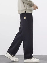 Men’s plus size wide leg jeans in dark indigo denim with a subtle beige patch on the back pocket shown from the back