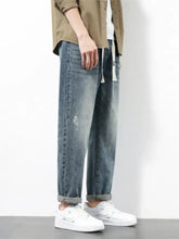 Men’s plus size wide leg jeans in light-wash denim with relaxed tapered fit and subtle distressing details