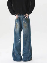 Men’s plus size wide leg jeans in medium blue denim with white paint splatter and faded distressed details