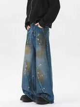 Men’s plus size wide leg jeans in faded blue denim with splattered gold and white paint accents