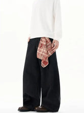 Men’s plus size wide-leg jeans in black styled with a red and beige detachable plaid square scarf tied at the waist