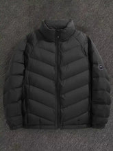 Men’s plus size zip up black quilted down jacket with high collar and circular logo patch on left sleeve