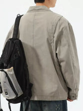 Black and gray mesh backpack with small front pocket complementing beige plus size trucker jacket design