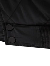 Men’s black quilted snap long sleeve jacket with two black circular buttons and ribbed fabric cuff detail