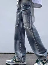 Distressed gray denim cargo pants with raw hem wide leg and frayed edges featuring multiple pockets for men