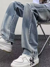 Men’s light-wash denim raw hem wide leg jeans with frayed distressed edges along the legs and cuffs