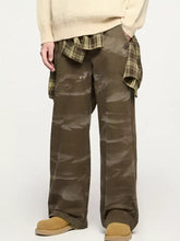 Men’s olive green relaxed fit cargo jeans in crinkled fabric with a plaid shirt tied at the waist