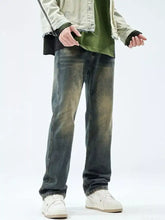 Distressed dark wash denim men’s relaxed fit jeans with faded green and brown stains for casual wear