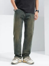 Men’s relaxed fit jeans in dark green denim with slight fading and subtle distressing for casual wear