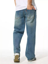 Men’s relaxed fit wash jeans in blue denim with a faded wash and classic five-pocket design for casual wear