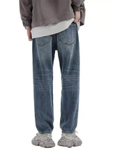 Men’s relaxed fit wash jeans in dark-wash denim with a relaxed straight-leg cut and classic back pockets shown from the back