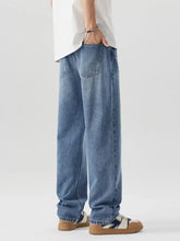 Mens relaxed fit wash jeans showing the back side in light-wash blue denim with a relaxed wide-leg cut and classic pockets