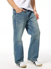 Men’s relaxed fit wash jeans in light-wash blue denim with a relaxed fit and subtle thigh distressing