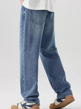 Men’s relaxed fit wash jeans in medium-wash blue denim with a relaxed straight-leg cut and classic back pockets visible
