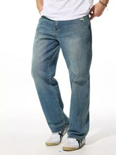 Men’s relaxed fit wash jeans in medium-wash blue denim with a slightly faded and distressed look and classic stitching