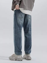 Men’s relaxed fit wash jeans in washed blue denim with a straight-leg cut and visible stitching details