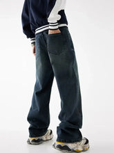 Dark indigo men’s relaxed fit washed jeans with wide-leg cut and visible stitching details in denim material