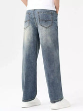Men’s relaxed fit wide-leg denim jeans in faded blue wash with subtle whiskering and reinforced stitching